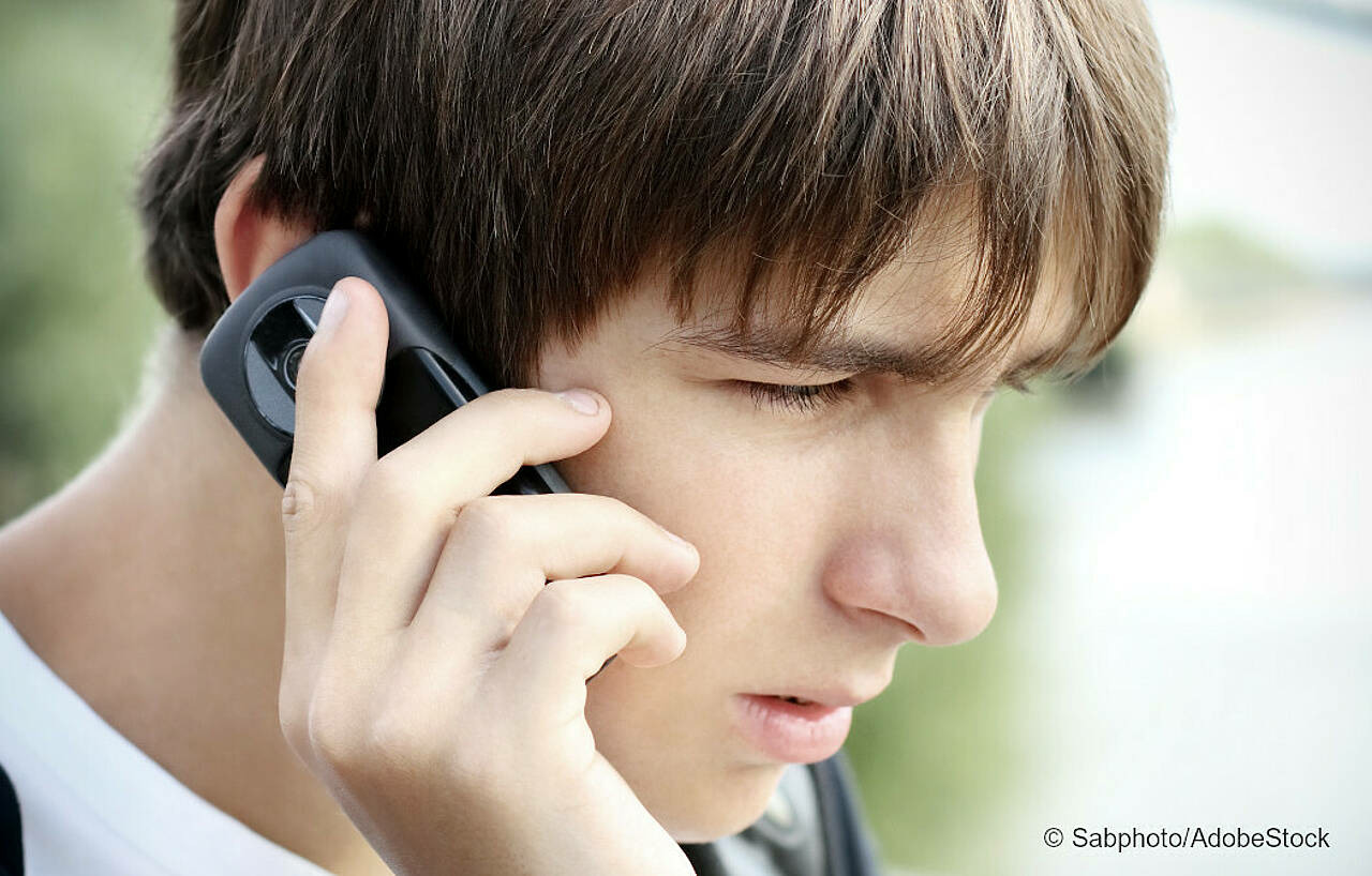 Sorgenvoller Teenager am telefon. Foto: Sabphoto/Adobe Stock