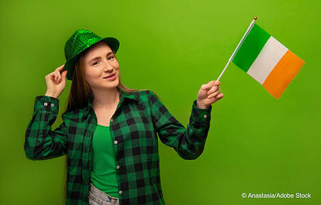 Junge Irin mit grünem Hut und Fahne. Foto: Anastasia/Adobe Stock.