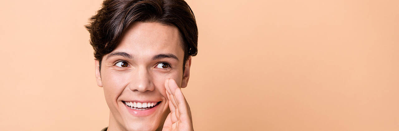 junger Mann flüstert. Foto: Deagreez/Adobe Stock.